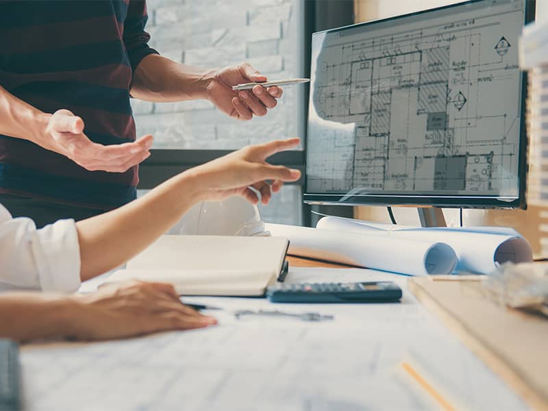 Zwei Fachleute – Ingenieur und Architekt – diskutieren gemeinsam über Pläne bei Architekturprojekt im Büro in Eschborn.