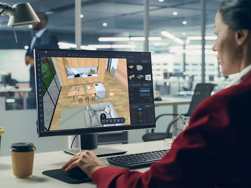 Frau beim Entwerfen mit 3D Modelling-Software am Desktop – moderne Architekturplanung für Wohnräume.