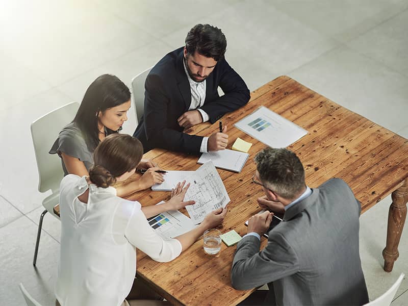 Zwei Fachleute – ein Architekt und eine Führungskraft – besprechen Baupläne im Büro als Teil der Bauleitung in Eschborn.