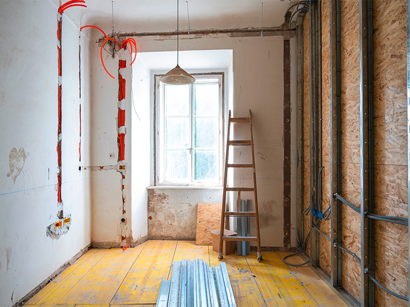 Erneuerung der Elektroinstallation in Neu-Anspach mit freigelegten Kabelkanälen und vorbereiteten Leitungswegen während der Renovierung eines Wohnraums.