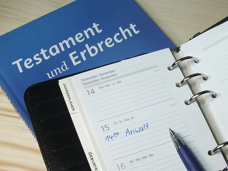 Aufgeklappter Kalender mit Anwaltstermin neben Buch „Testament & Erbrecht“, Fokus auf Erbrecht in Bad Homburg.