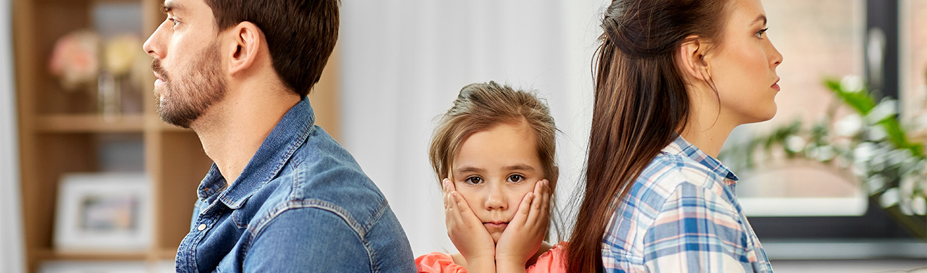 Vater, Mutter und Tochter sitzen traurig zu Hause – ein emotional gespannter Familienkonflikt beim Thema Trennung.