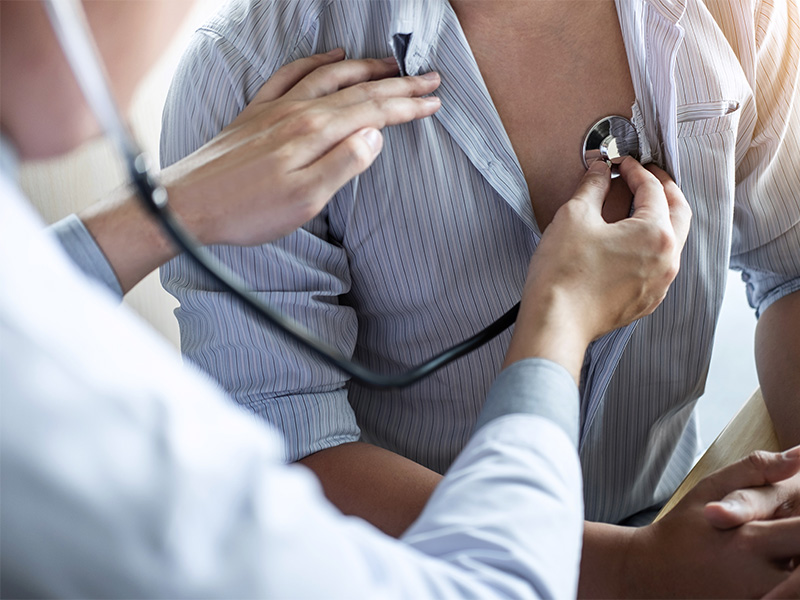 Arzt untersucht Patientin mit Stethoskop und bespricht Untersuchungsergebnisse zur Früherkennung beim Hausarzt
