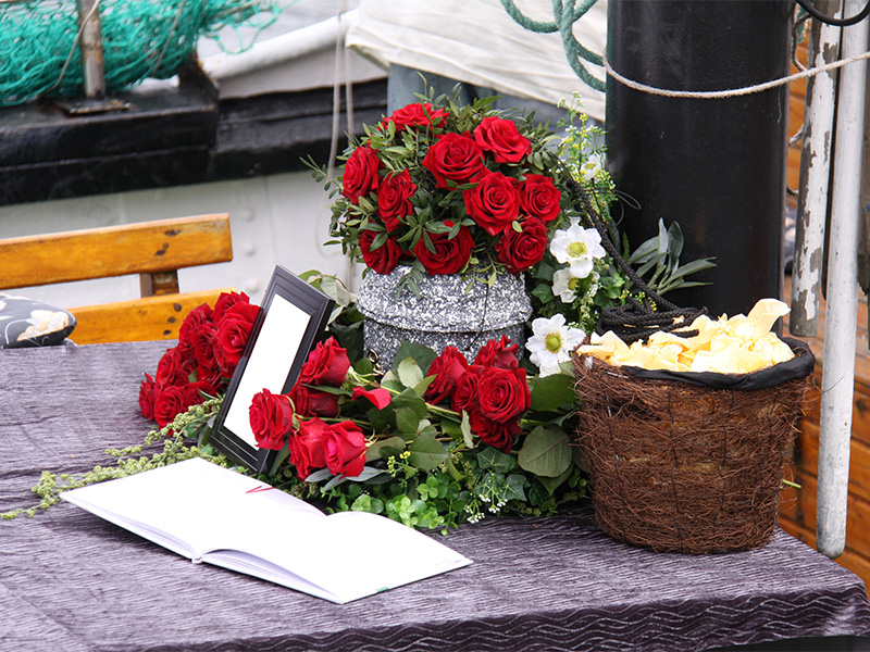 Urne mit Blumen und Erinnerungsfoto bei einer Seebestattung auf der Ostsee als persönlicher Ort des Abschieds.
